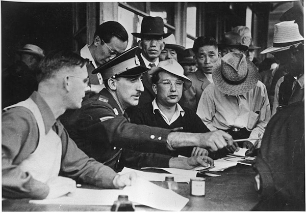 RCMP officer sits at registration table surrounded by group of people