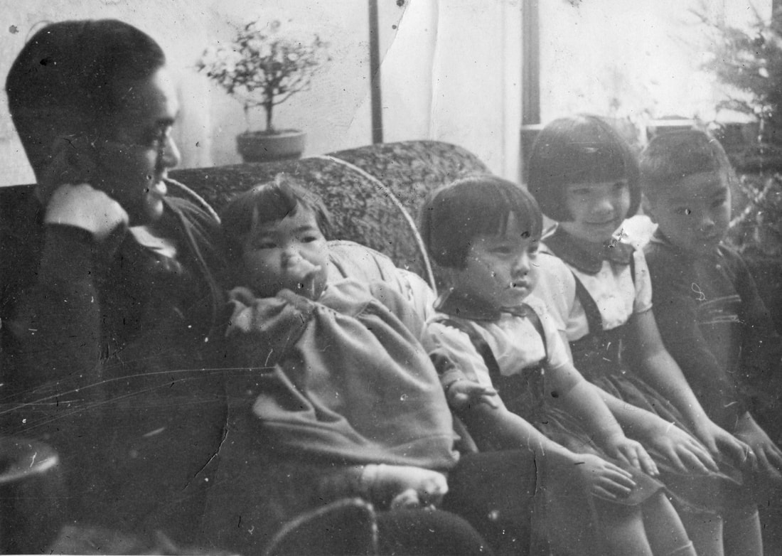 A father and his children sit on a couch